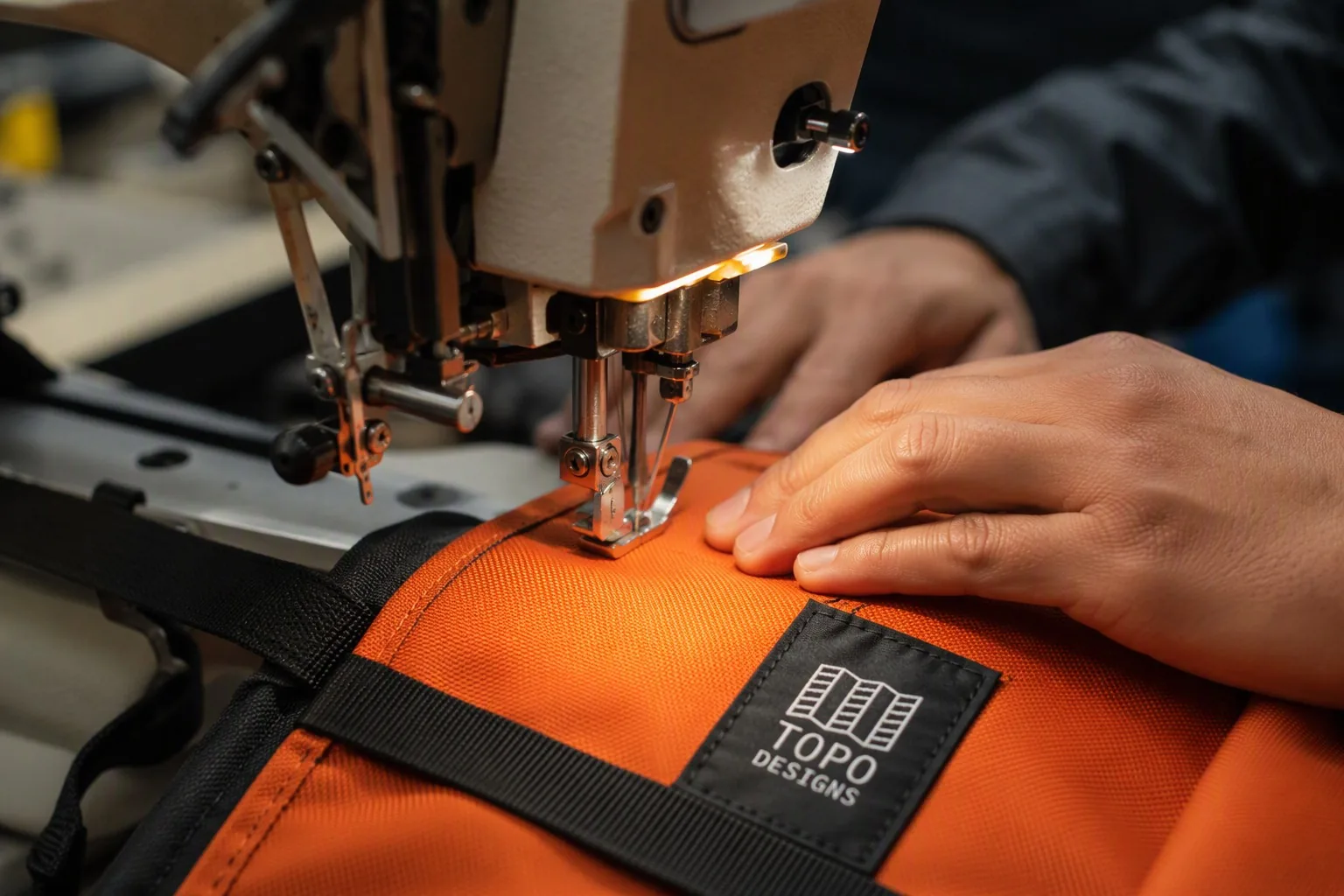 Industrial sewing machine stitching a backpack panel