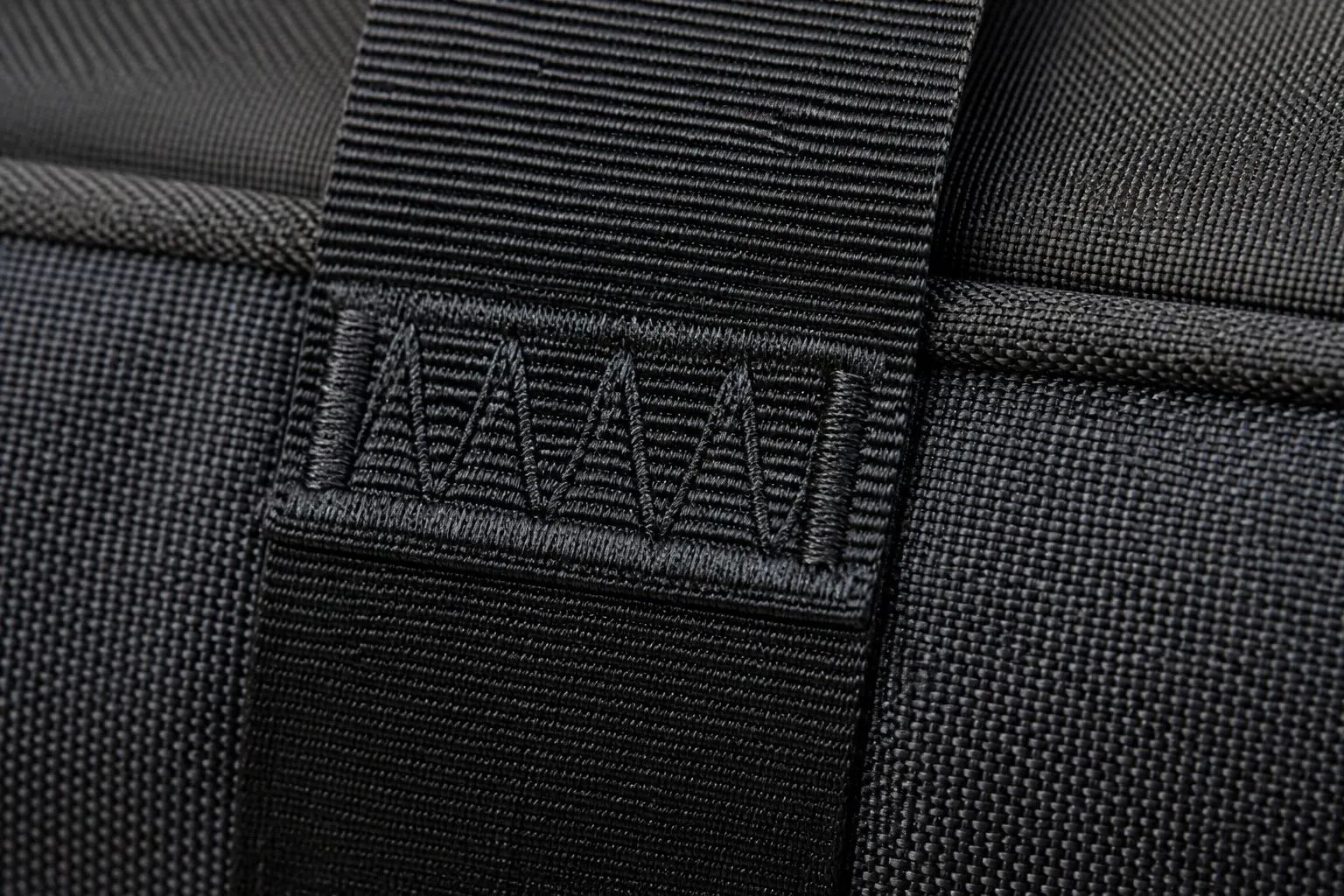 Reinforced bar-tack stitching on backpack strap attachment