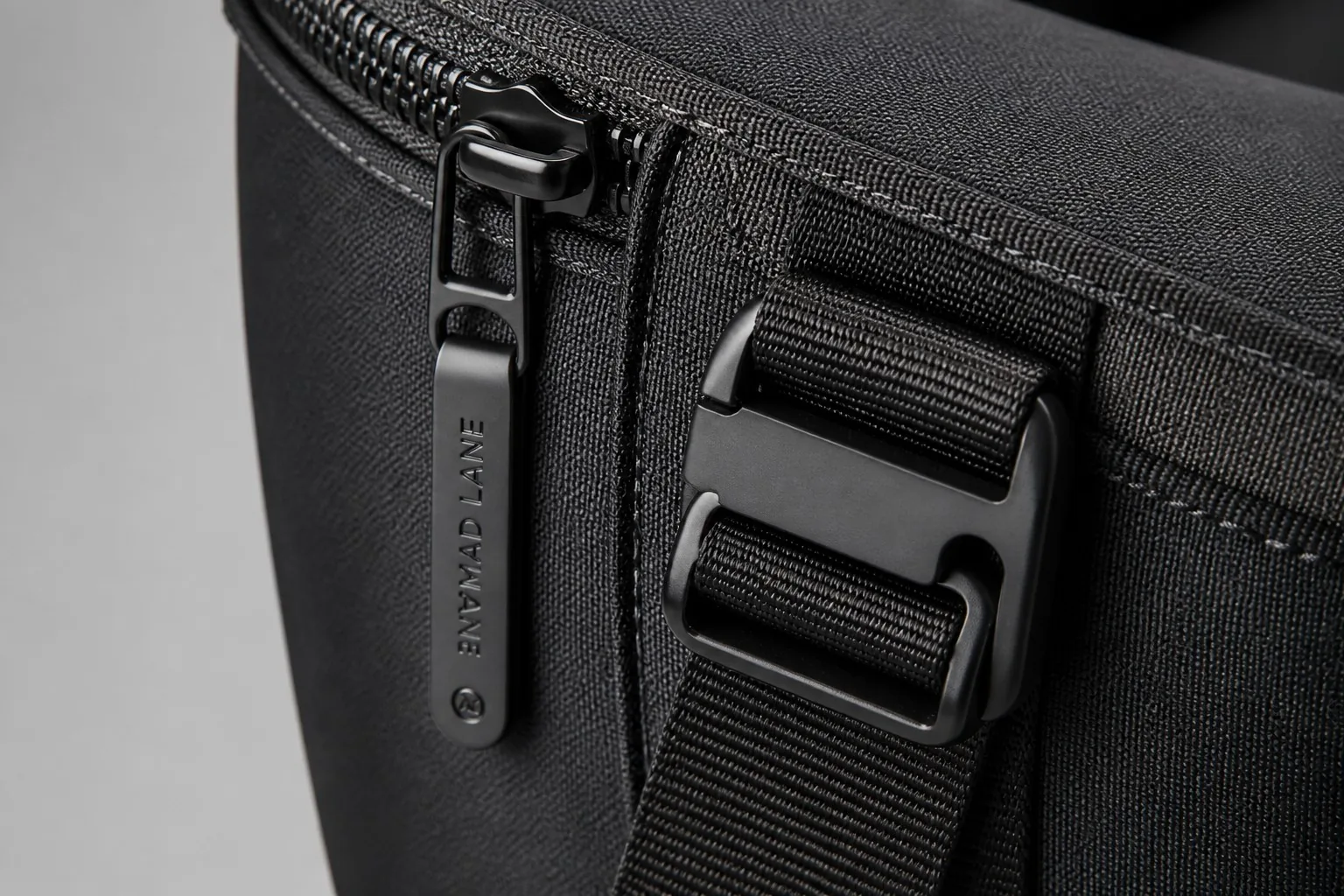 Premium matte black zipper pull and buckle detail on finished backpack