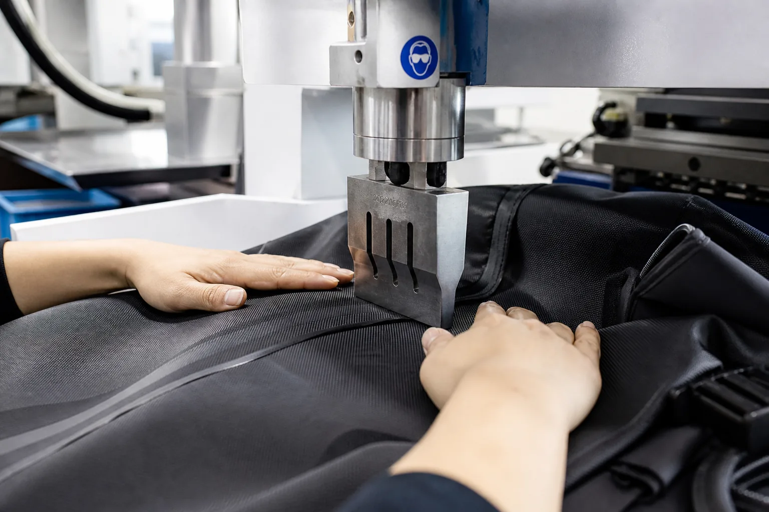 Operator using heat press equipment in a bag workshop
