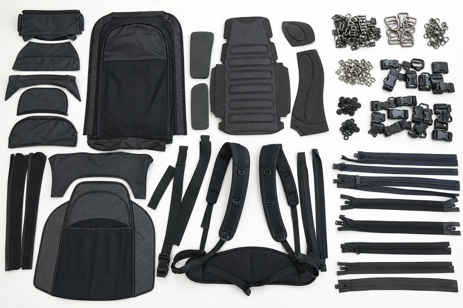 A disassembled backpack sorted into separate material groups: fabric panels, foam, metal hardware and plastic buckles